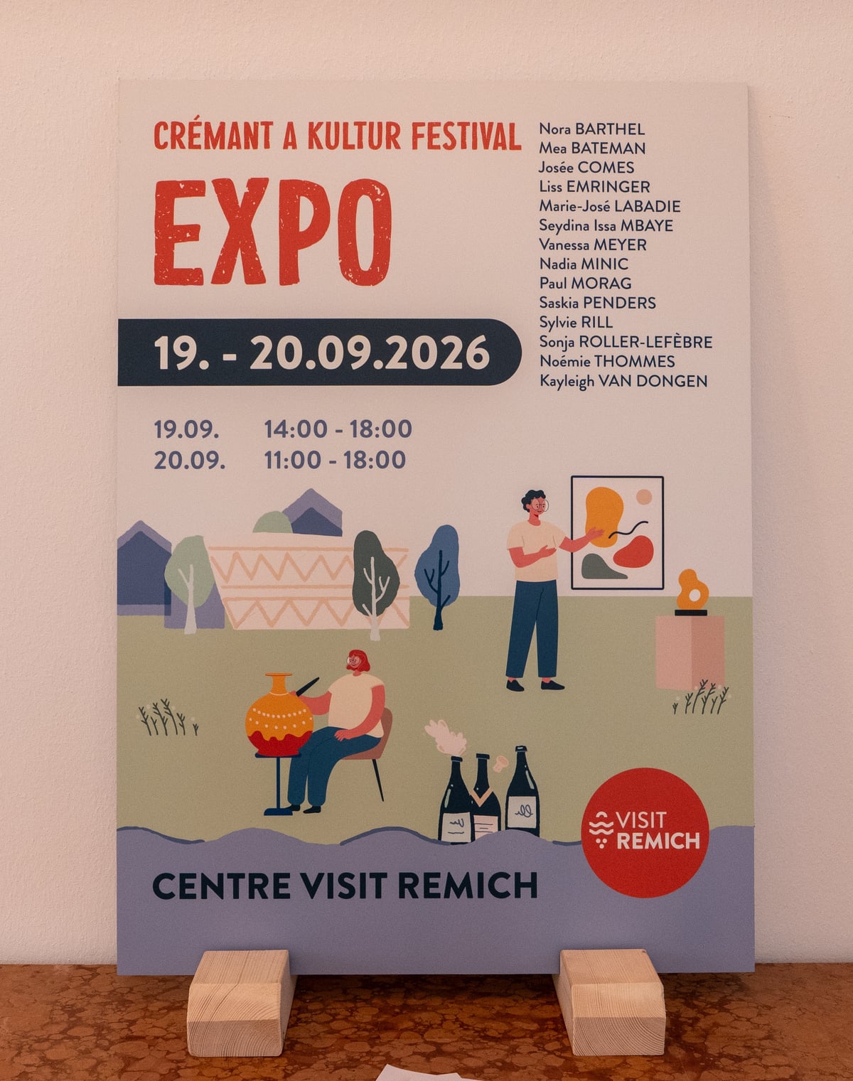The exhibition placard at the Centre visit Remich, announcing the Crémant a Kultur Festival Expo on 19 and 20 September 2026 with the opening hours and the names of the fourteen exhibiting painters, Kayleigh van Dongen among them.
